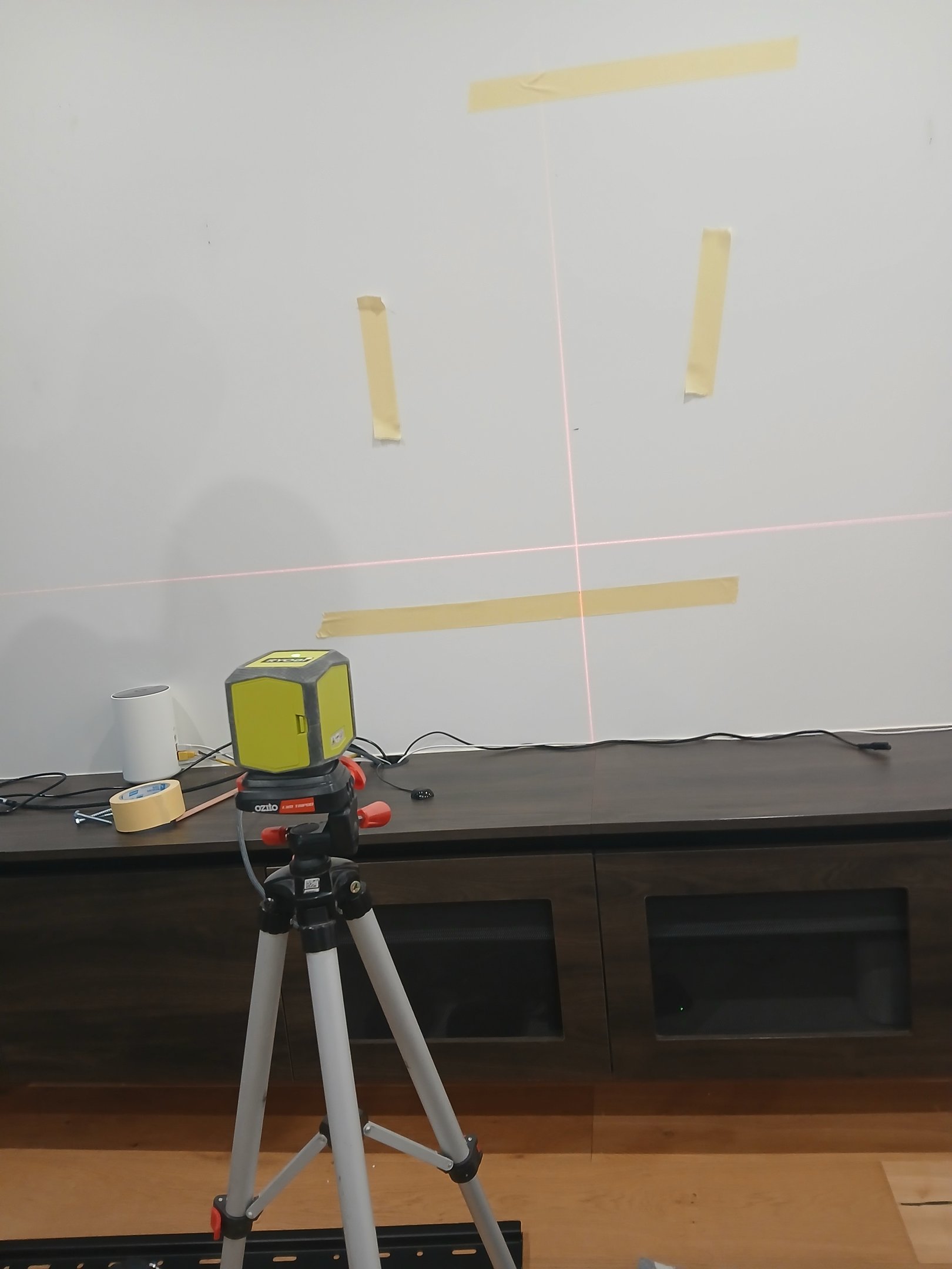 Installer scanning a wall for studs and cables before mounting a TV