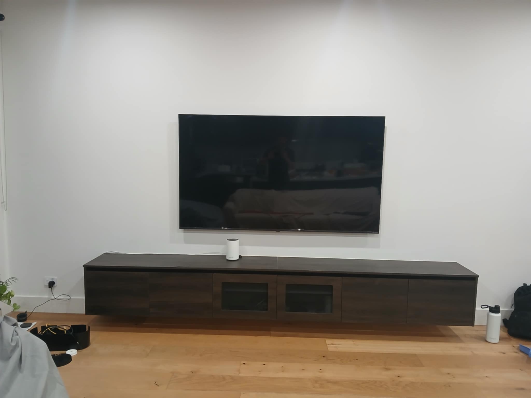 Mounted TV switched on and tested, area tidied and packaging removed