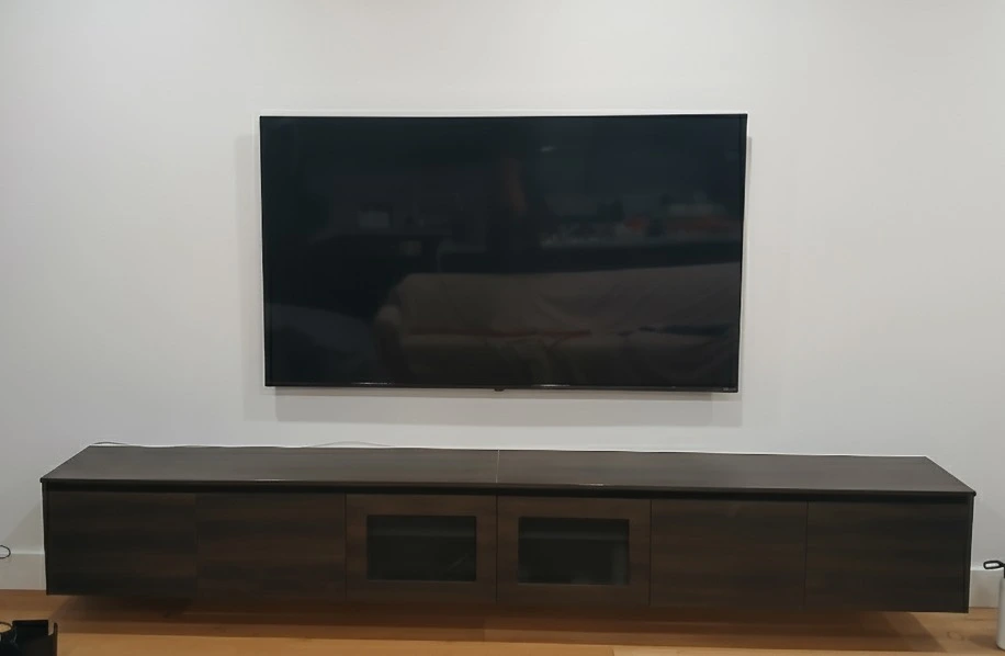 Space-saving ultra slim TV wall mounting for a compact apartment living room in Melbourne CBD.