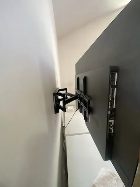 Full motion TV wall mount from the side, cables run cleanly