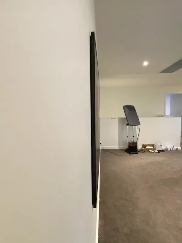 Slim profile wall mounted TV sitting close to the wall with no visible cables