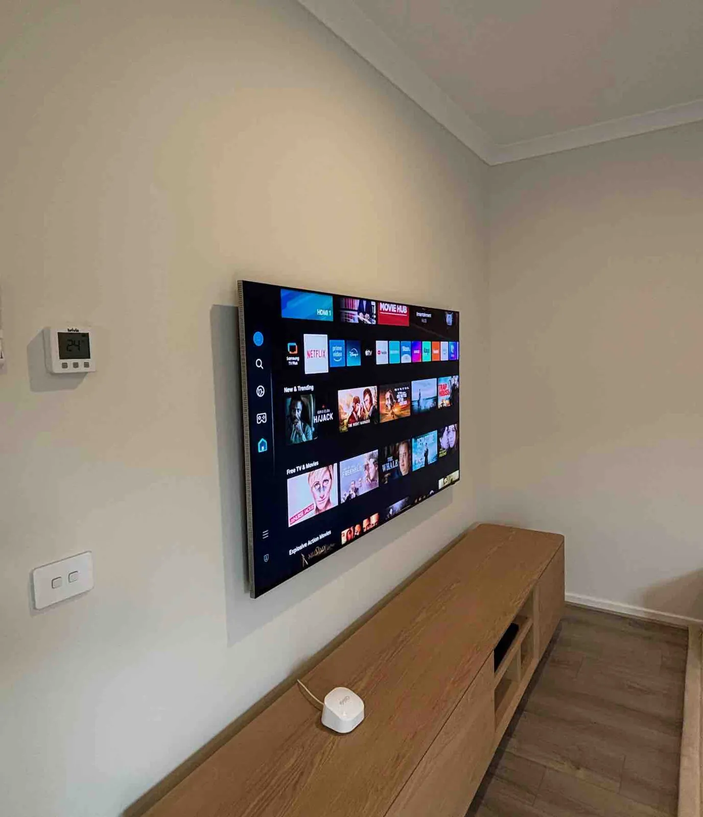 Wall mounted TV above dark floating TV unit