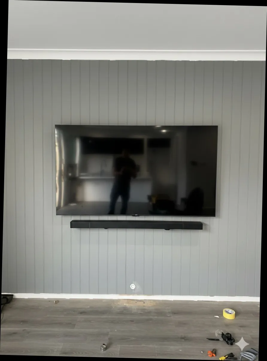 TV and soundbar mounted on panelled feature wall