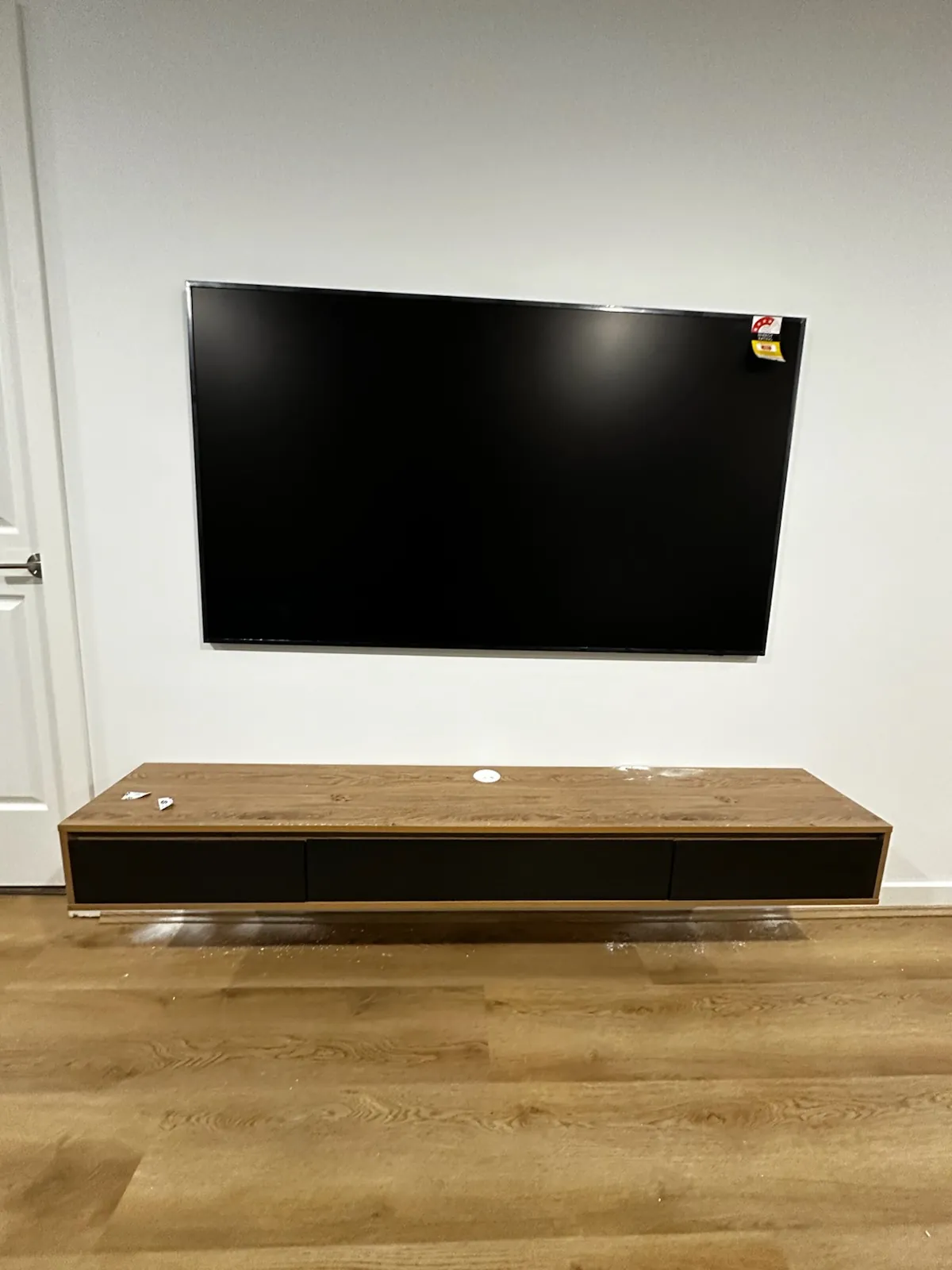 Large TV mounted above a floating timber unit