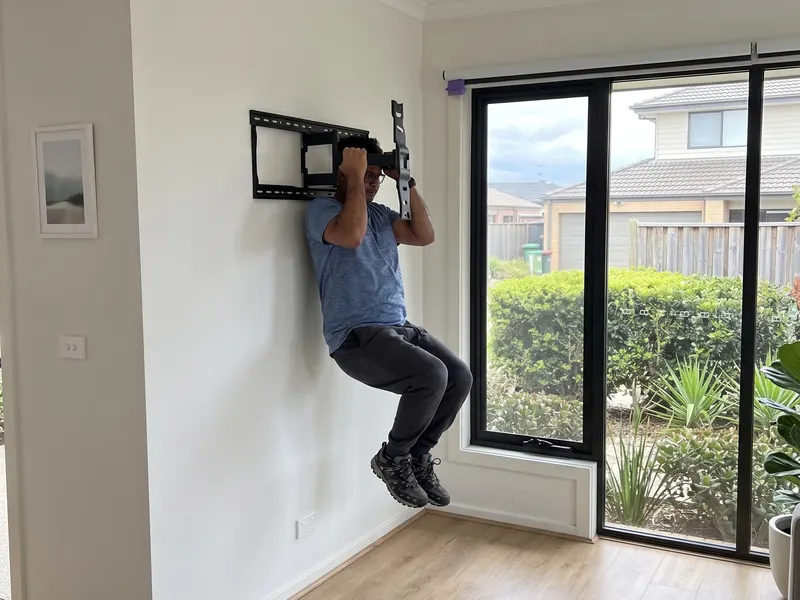 Sachin testing the strength of a freshly installed TV wall mount